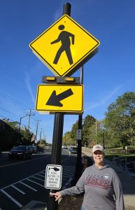 Erika Lindeberg poses with crossing sign located on UConn's Storr's campus