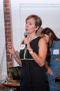 Dr. Andrea Shields holds a microphone while addressing an event.