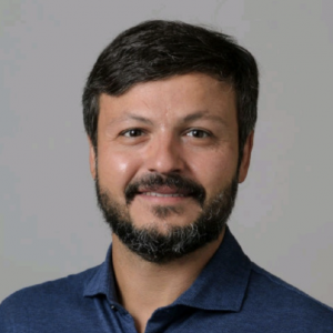 Headshot of a man wearing a dark blue collared shirt