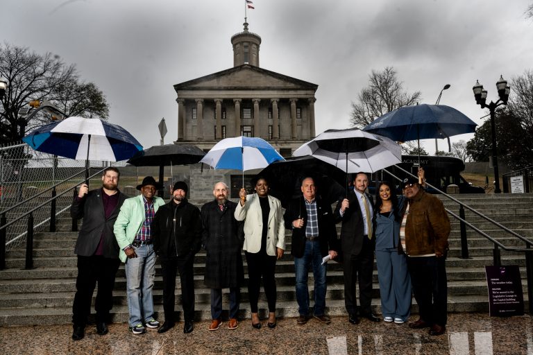 People stand at the bottom of stairs leading up to the Tennessee statehouse.