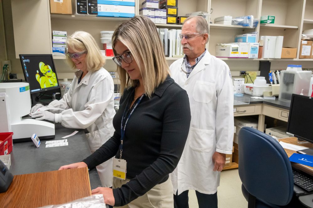 Three people working in lab setting
