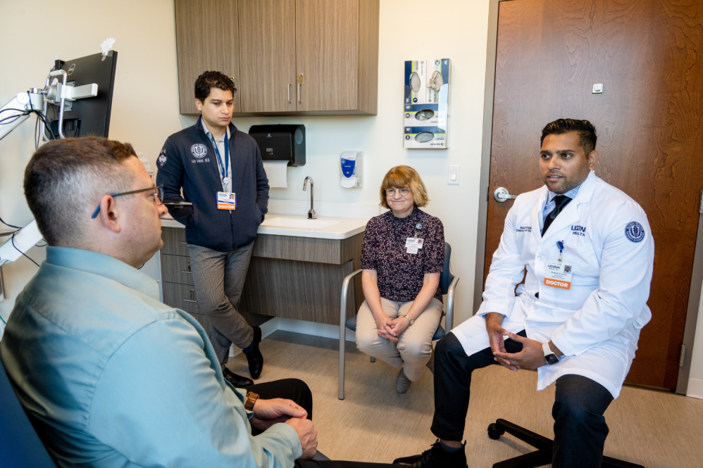 Dr. Shakaib Kahn and the Huntington disease team talking in a patient room