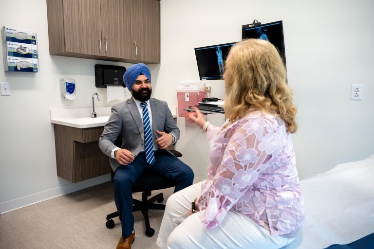 Dr. Hardeep Singh is speaking with a female patient in a patient room