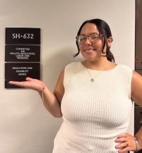 Samantha Valle ’24 (CLAS), MPP ’26 stands in front of black sign.