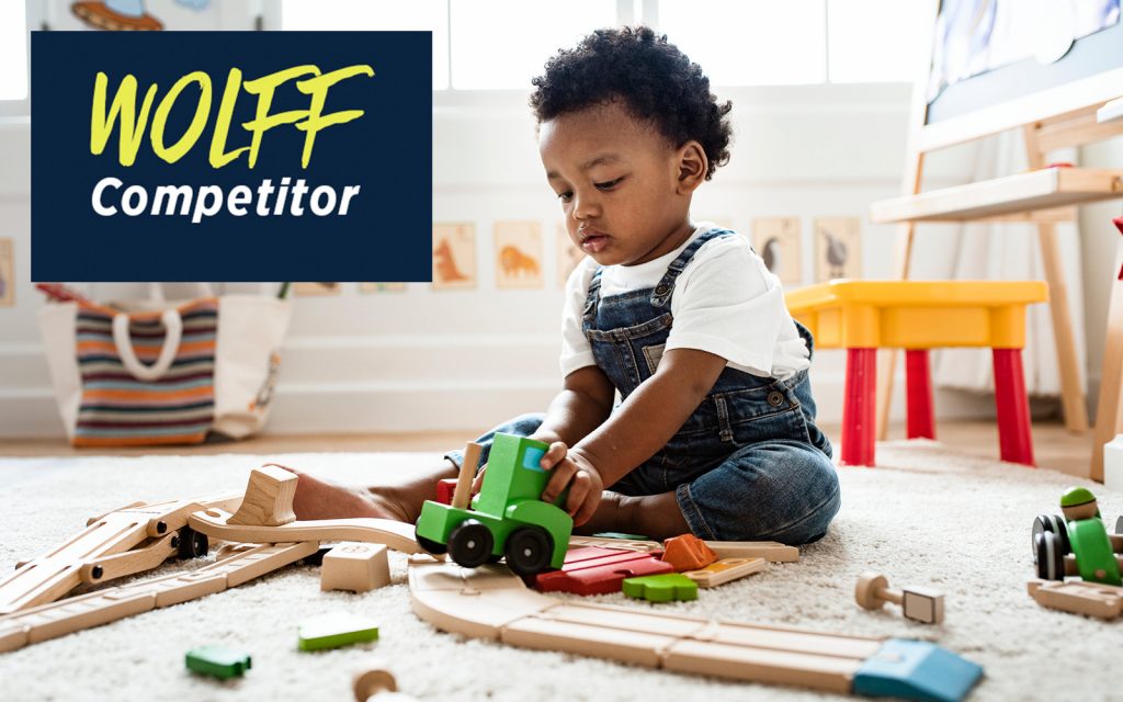 A toddler plays with toys on a living room floor.