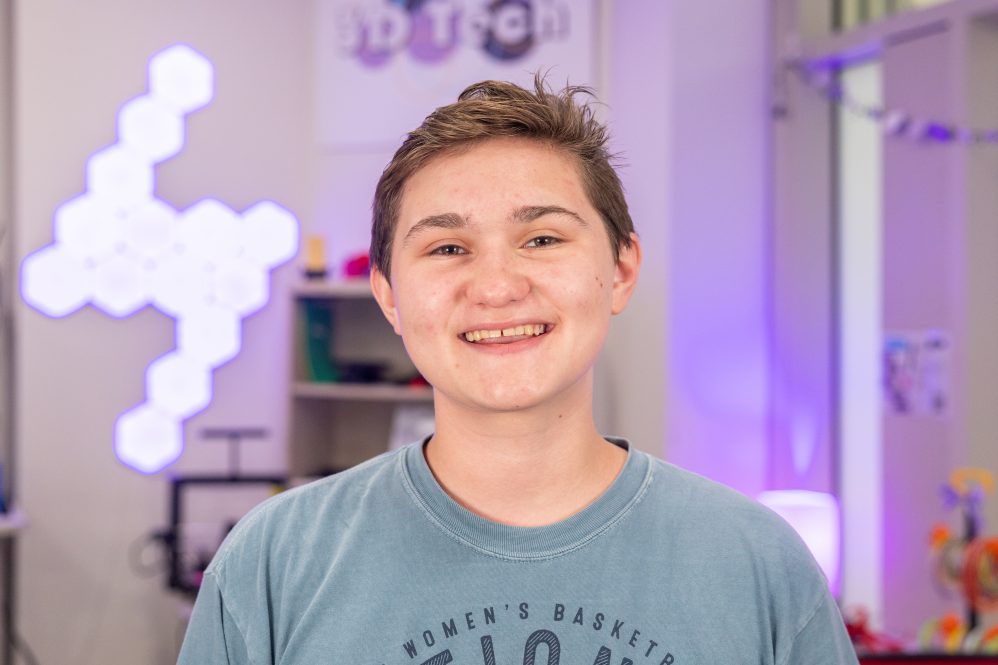 A student in front of a lightup geometric display