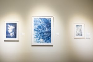 Three photos of clouds hanging on a wall