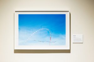 A photo of clouds in a frame hanging on a wall