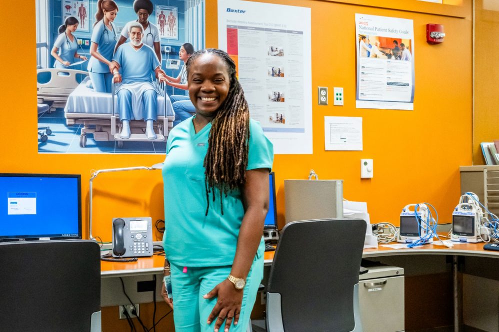 Desiree Mahon, clinical health coordinator, standing in UConn Health clinical with educational mobility posters