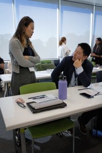 A man and a woman networking in a busy room.