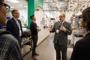 A man leading a tour through a laboratory