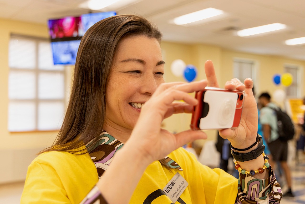 UConn Waterbury Dean Fumiko Hoeft takes a picture with her cell phone.