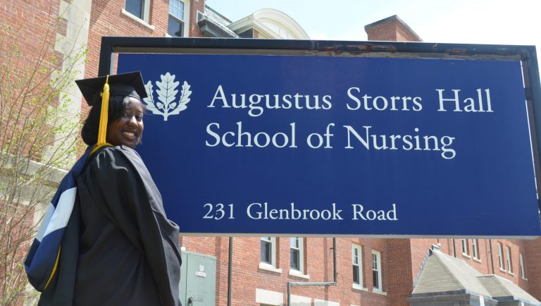Vanessa Bolling in front of the nursing building in in a cap and gown in 2015. (Contributed Photo)