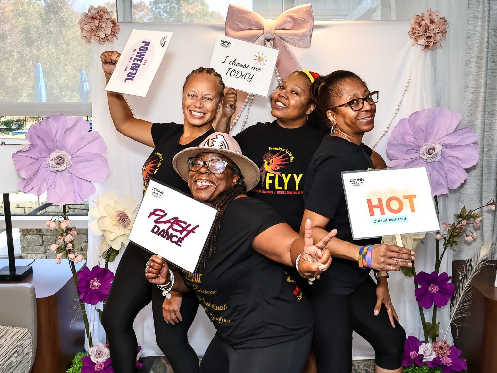 FLYY and team holding up signs and celebrating happily at photo booth