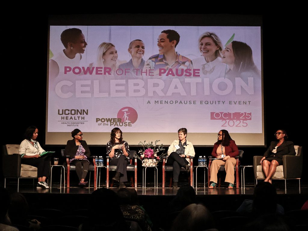 Panel of six people on stage with a backdrop behind them for Power of Pause event