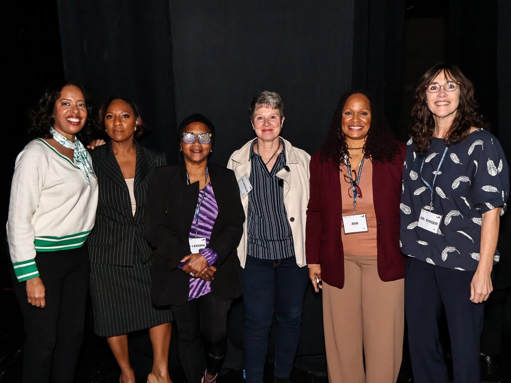 Panelists posed for a picture together on stage.