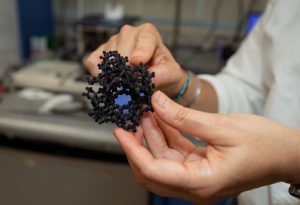 Hands holding a representative model of a zeolite.