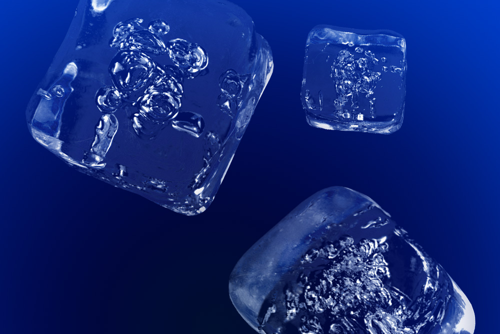 Three clear ice cubes floating against a deep blue background, showing detailed air bubbles and smooth surfaces.