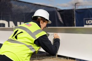Elisabeth DeLuca signing the beam for the new Elisabeth DeLuca School of Nursing building.