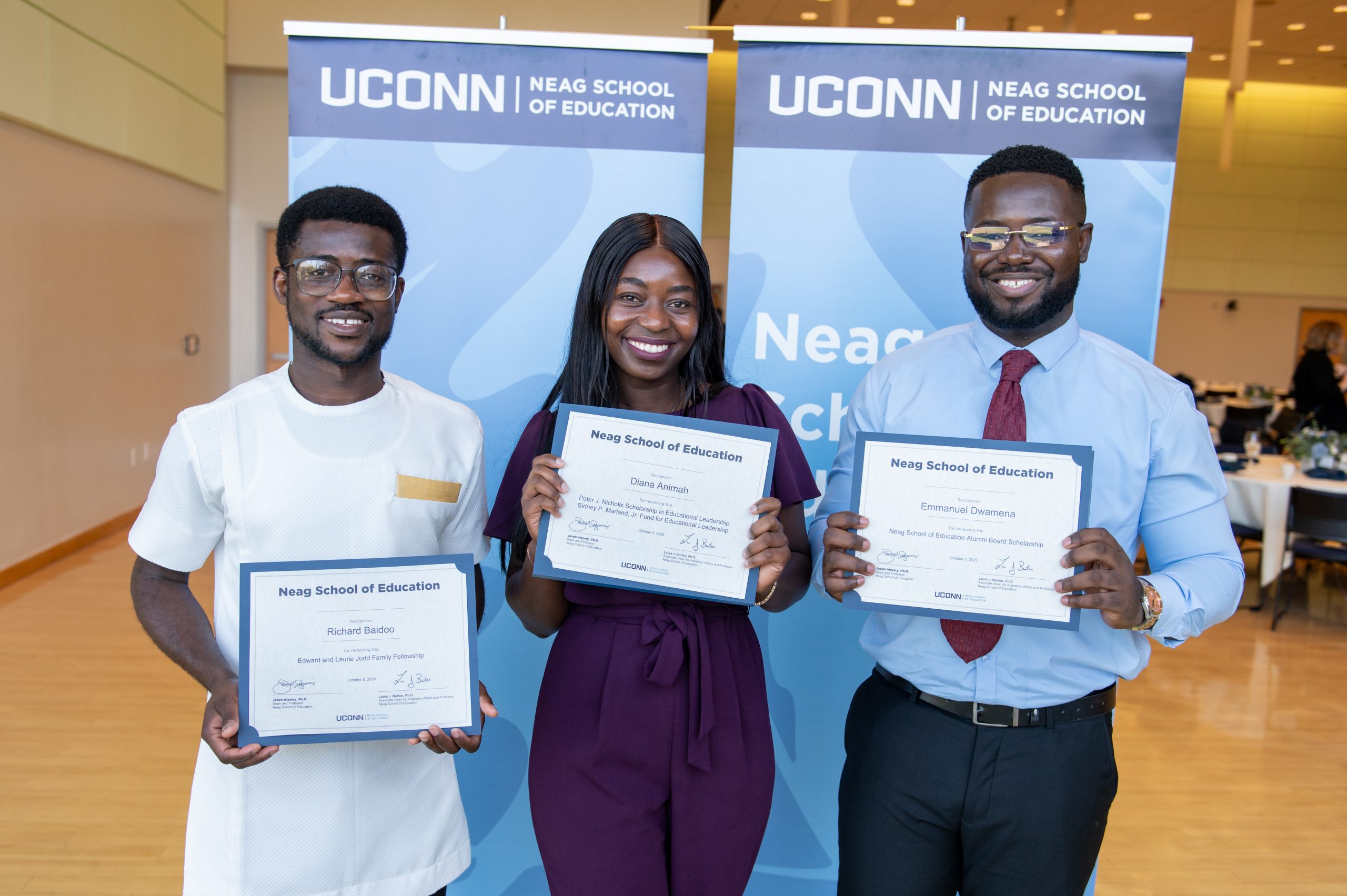 Three Neag School students holding certificates from the Neag School Scholarship Celebration.
