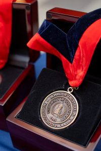 A close up of a medal with a red and black ribbon