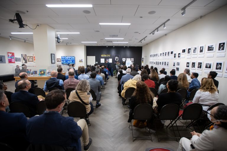 A classroom full of people looking at a presenter in the front of the room