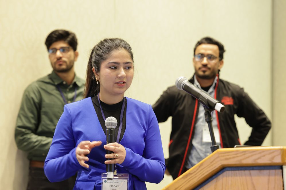 Three students presenting at a podium.