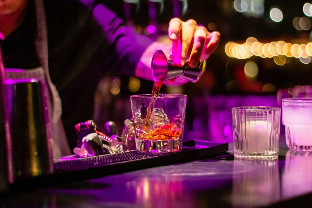 Alcohol being poured into a glass at a bar
