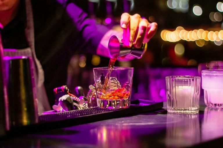 Alcohol being poured into a glass at a bar