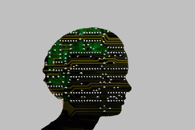 An abstract image of a circuit board cut in the shape of a human head's silhouette