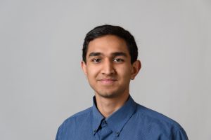 Headshot of a young man wearing a blue button-down shirt.