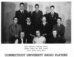 An archival black and white photo showing students posing in suits and dresses.