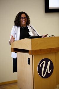 Rashi Akki speaking at a podium.