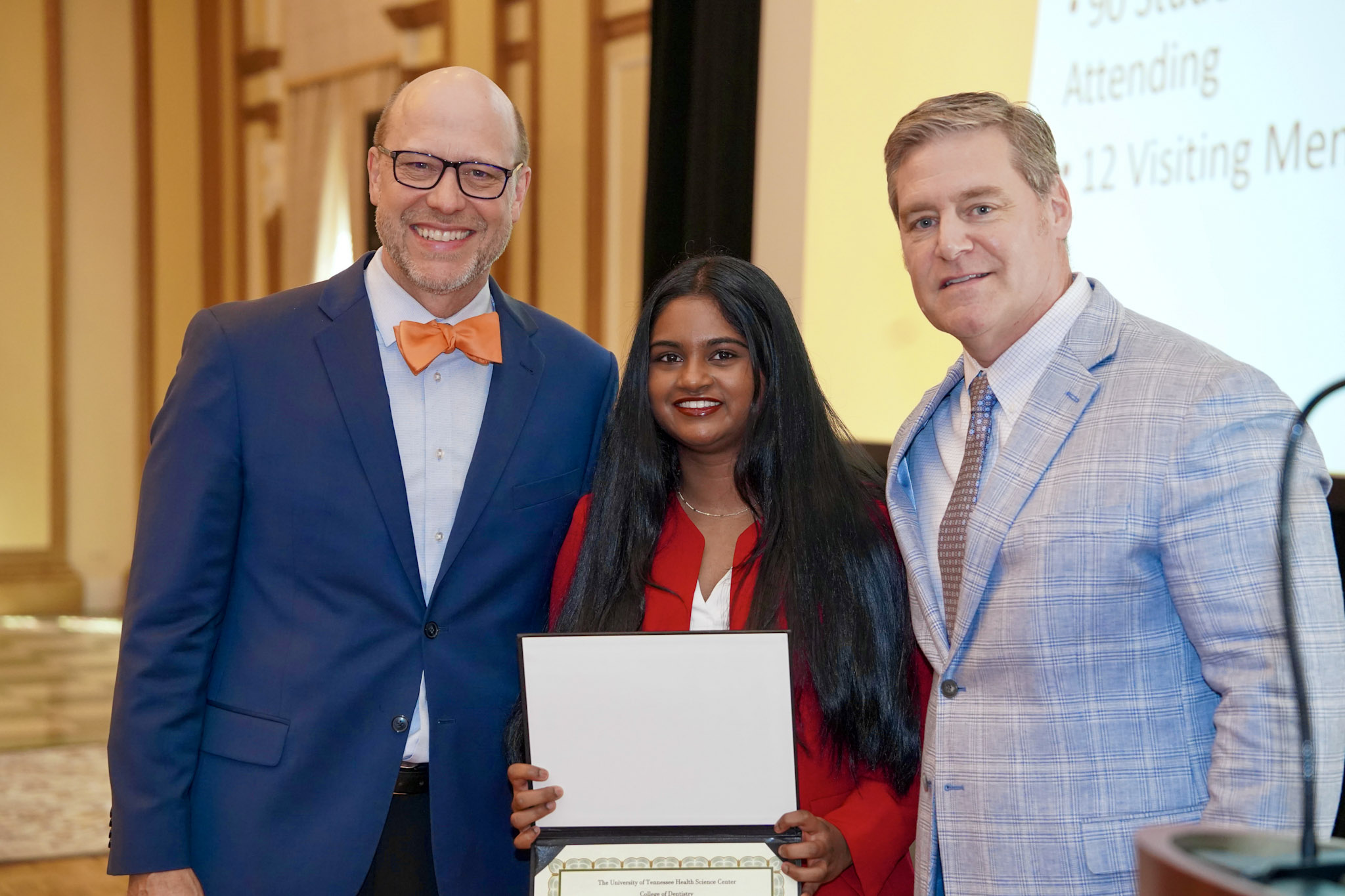 two dentists and student with award