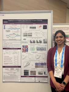 Sai standing beside her poster at the OTS Conference