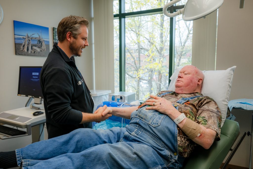 Mohs surgery expert Dr. Dan Klufas thanking Veteran and longtime, grateful UConn Health dermatology patient Michael Puttin with a handshake.