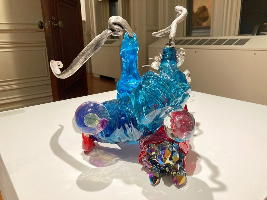 An abstract sculpture made of objects found along the beach, whether natural like quartz and oyster or man-made like plastic water bottles.