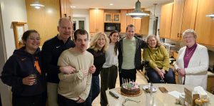 a group of men and women stand in a kitchen