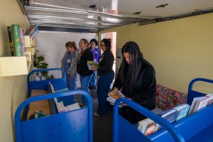 A group of female employees in the bookmobile getting books
