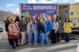 a group of people standing in front of the bookmobile