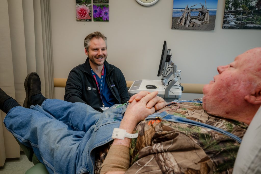 In exam room, Veteran and UConn Health dermatology patient with his Mohs Surgeon Dr. Daniel Klufas