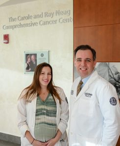 Man and women standing in front of cancer sign