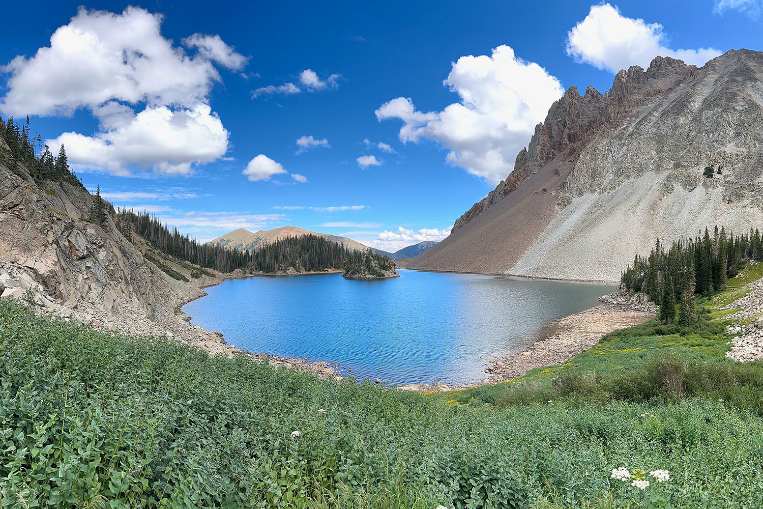 A scenic scene of a mountain and clouds reflecting in a pond