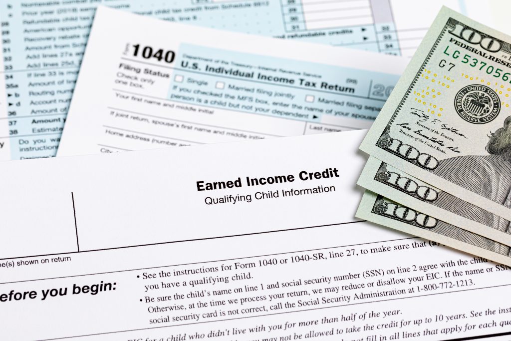 Earned income tax credit form with money stacked on top