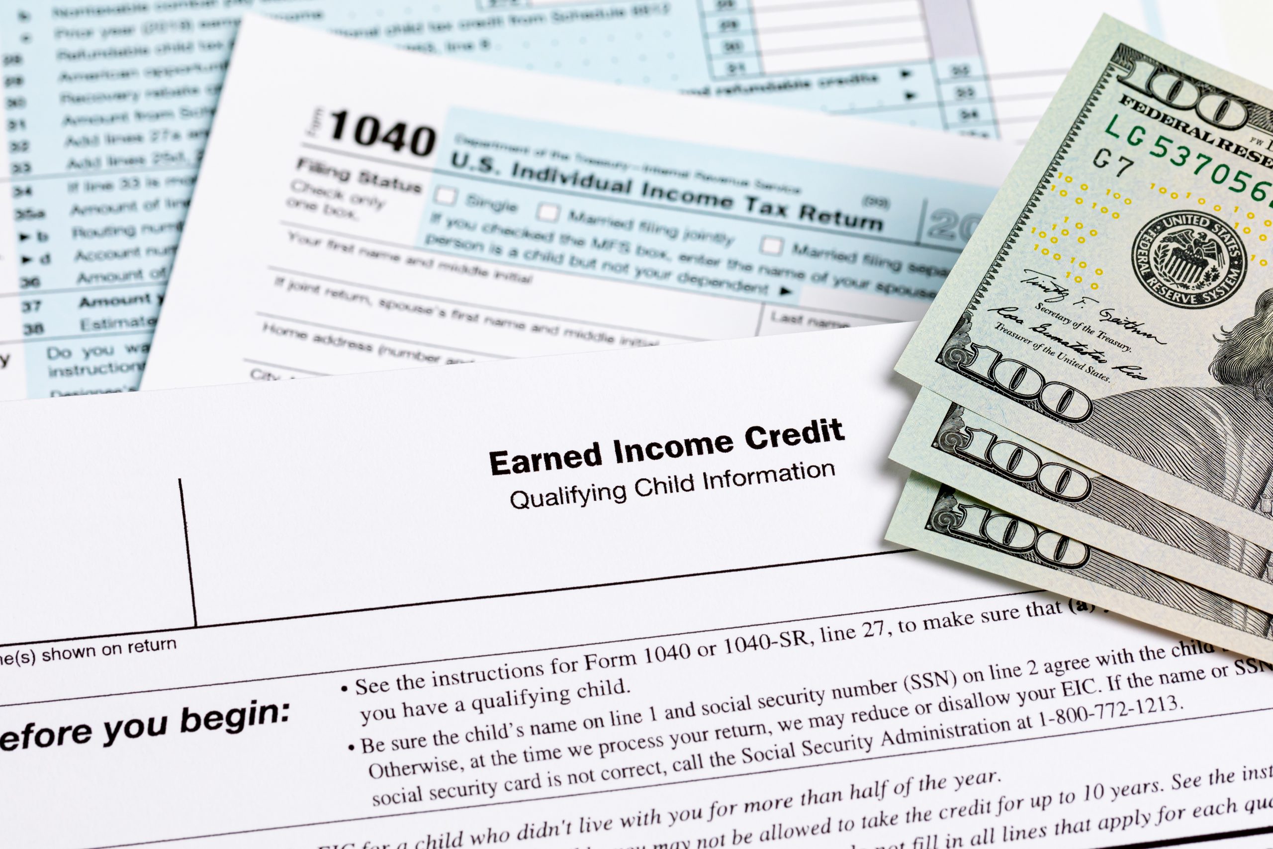 Earned income tax credit form with money stacked on top