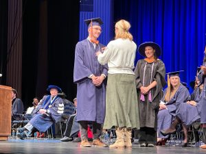 A UConn Nursing Accelerated Second-Degree BS/CEIN graduate getting pinned at commencement.