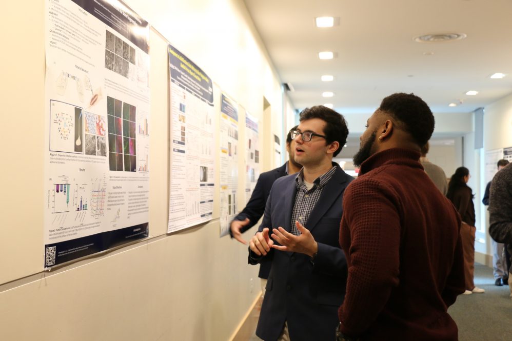 two men infront of research poster