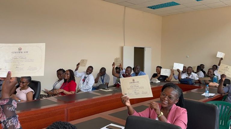 Trainees proudly holding up their awarded certificates.