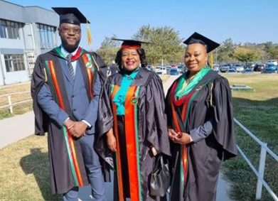 In their caps and gowns some graduates outside smiling.
