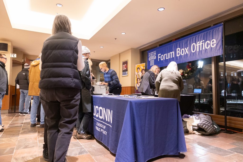 People stand in a lobby, waiting to get inside an auditorium